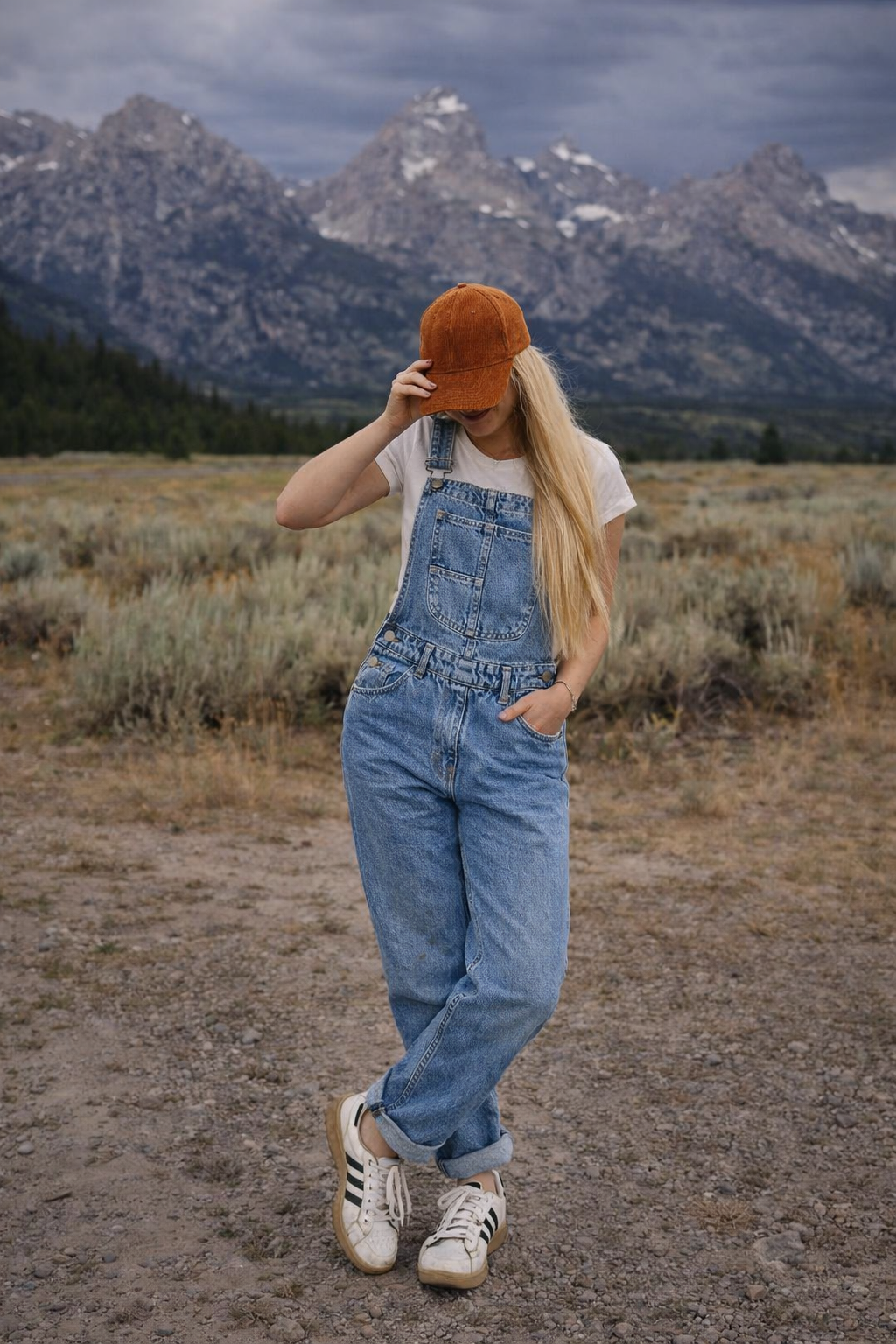Plus size woman modeling baggy denim overalls with flattering relaxed fit