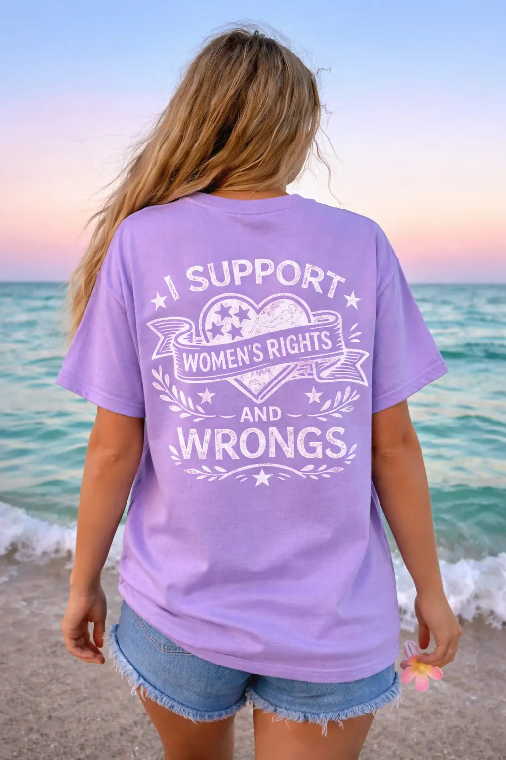 Back of I Support Women's Rights And Wrongs feminist graphic tee — vintage distressed print on lavender Comfort Colors shirt at beach sunset