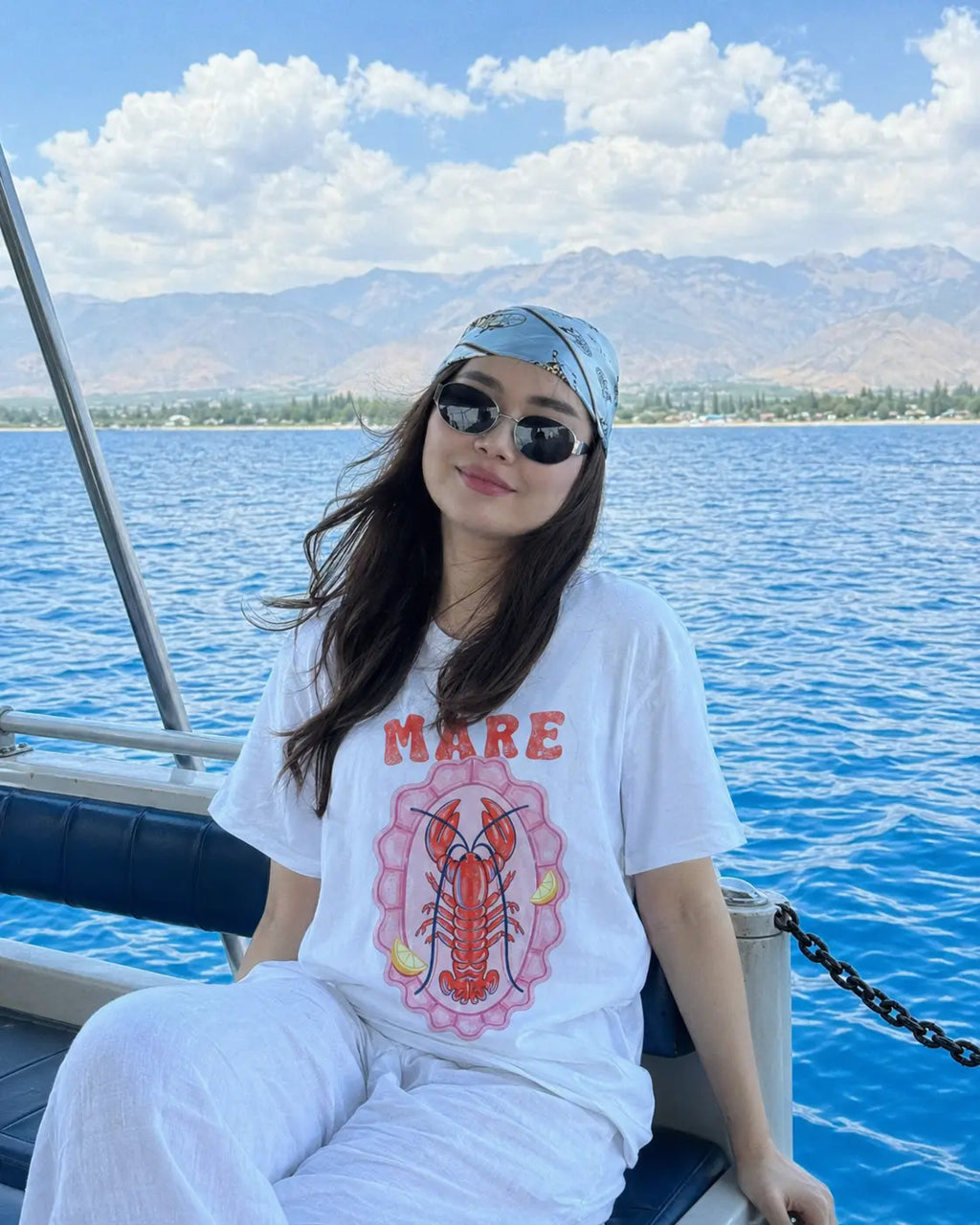 Mare lobster shell graphic tee for women in white — oversized Comfort Colors coastal t-shirt on boat