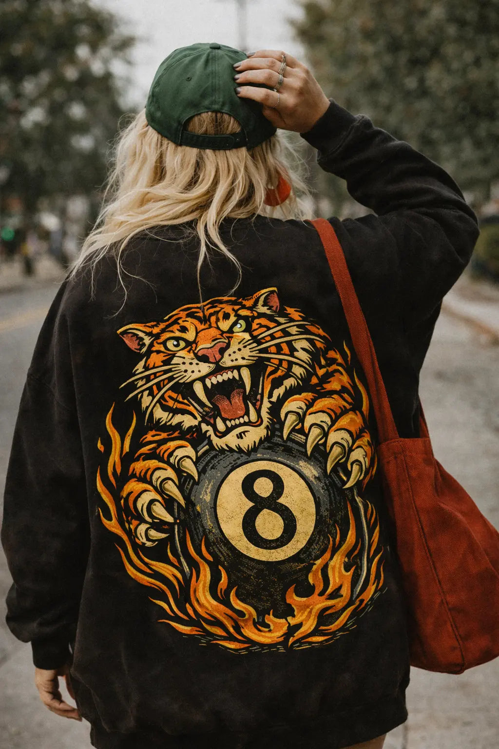 lose-up of retro graphic sweatshirt back print featuring a roaring tiger gripping a flaming 8 ball, 90s tattoo art style
