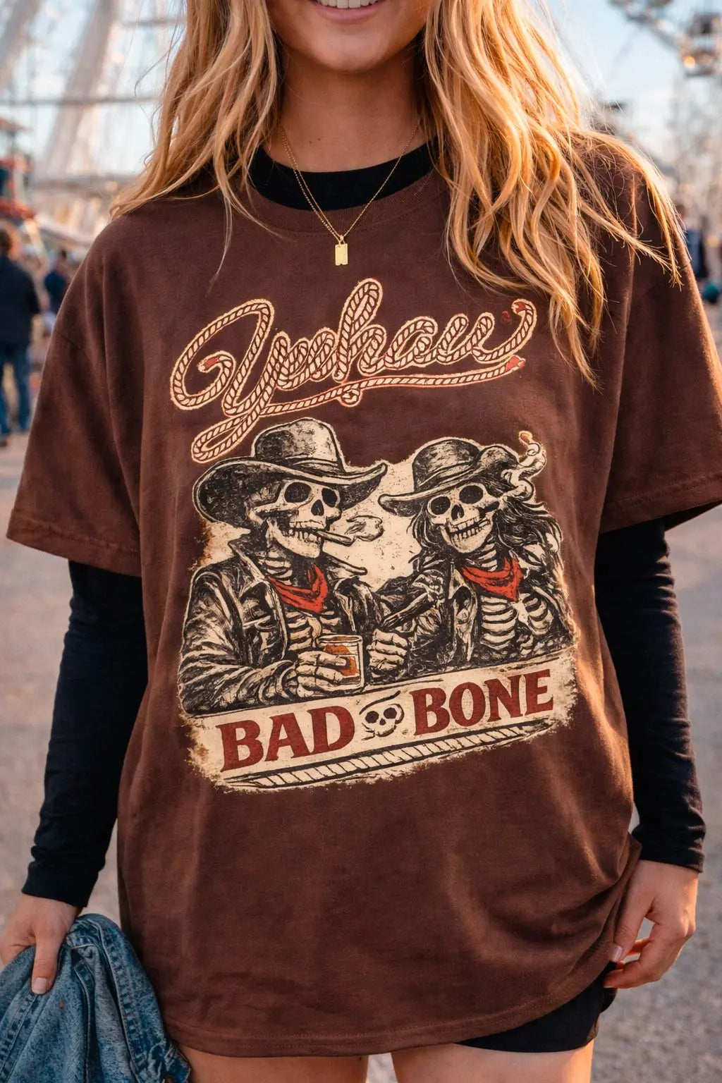 Close up of Yeehaw Bad to the Bone vintage skeleton cowboy graphic on brown Comfort Colors oversized t-shirt — western graphic tee for women