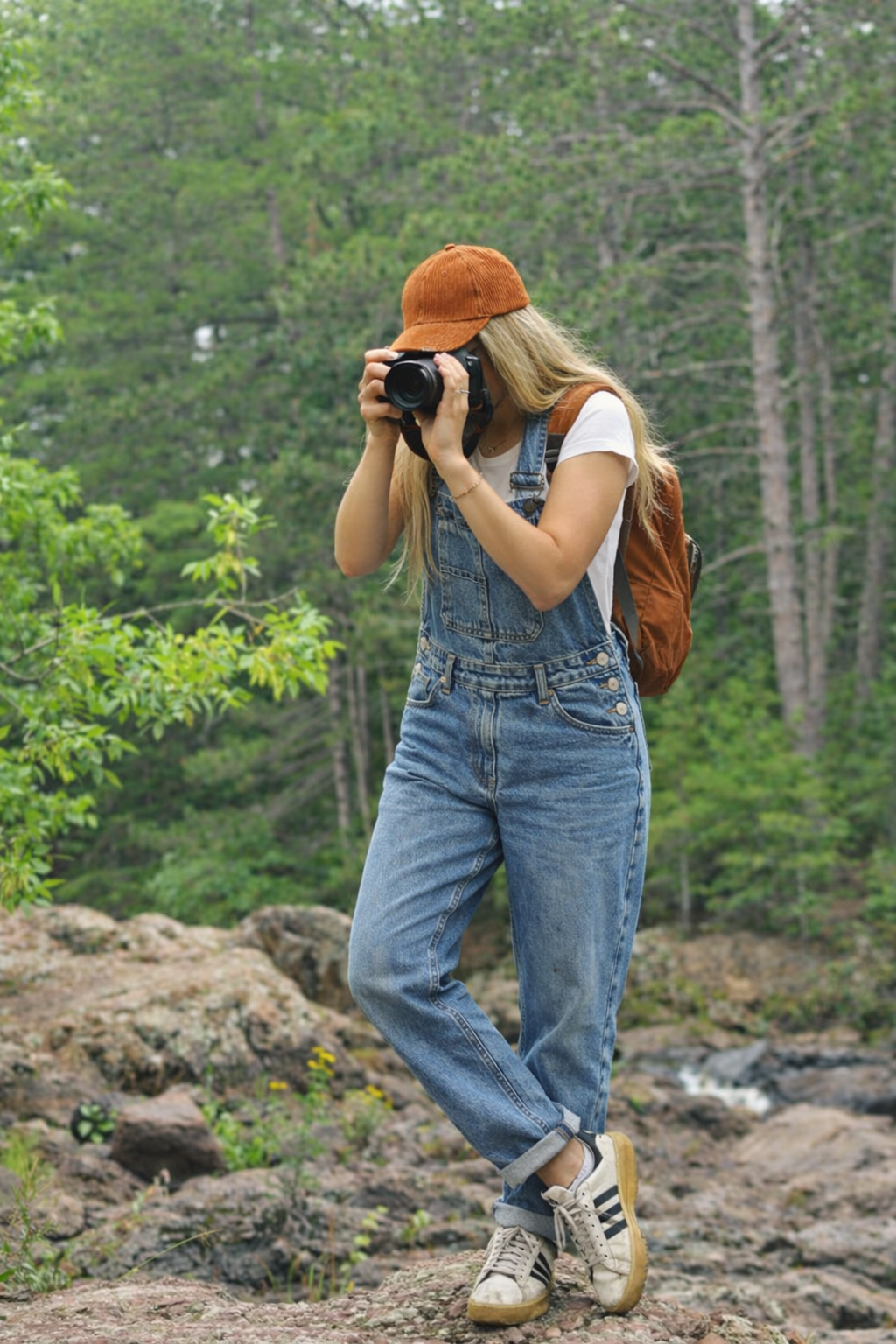 Women's baggy denim overalls layered with chunky knit sweater for fall style